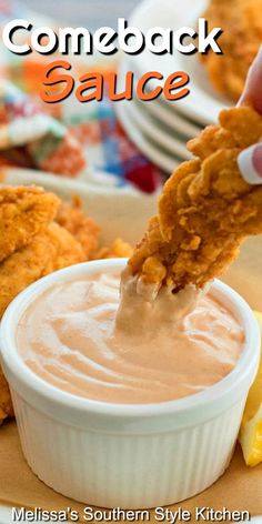 a spoon full of sauce being lifted from a white bowl with chicken wings in it