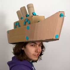 a young man is wearing a cardboard box on his head with blue polka dots around it