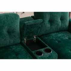 a green couch with two speakers in the center and an arm rest on one end