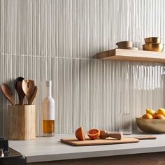 a kitchen counter with utensils, oranges and other food items on it