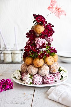 a cake made to look like a tower with flowers on top and balls in the middle