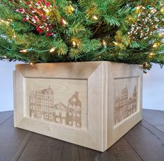 a wooden box sitting on top of a table next to a christmas tree with lights