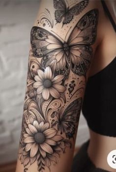 a woman's arm with butterflies and flowers on it