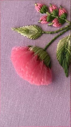 some pink flowers and green leaves on a purple cloth