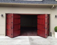 two red garage doors open in front of a house