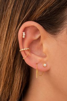 a woman's ear with three different types of piercings