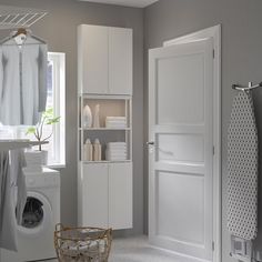 a washer and dryer in a small room with wooden cabinets, white walls and flooring