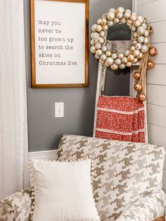 a christmas wreath is hanging on the wall next to a couch with pillows and throw pillows