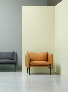 two couches sitting next to each other in front of a gray and yellow wall