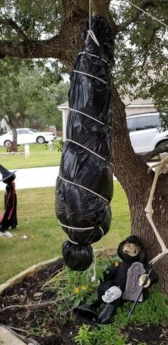 a halloween decoration hanging from a tree in the yard