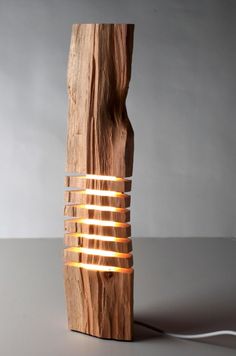 a lamp made out of wood and wire with light coming from the top on it