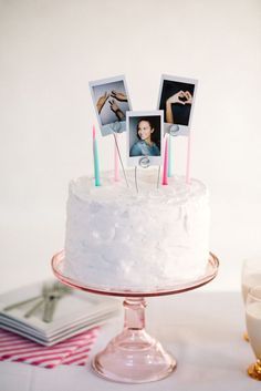 a white cake with three photos on top and candles sticking out of the icing