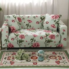 a living room scene with focus on the couch and rug, it appears to be covered in floral fabric