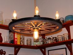 a light fixture hanging from the ceiling in a room with shelves and pictures on it