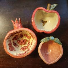 three pieces of fruit sitting on top of a wooden table next to an apple and another piece of fruit