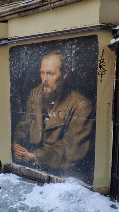 a painting of a man with a beard on the side of a building in winter