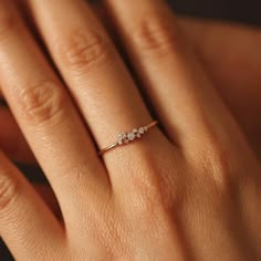 a woman's hand with a diamond ring on top of her finger and an engagement band