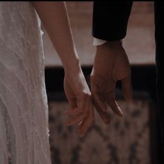 the bride and groom are holding hands