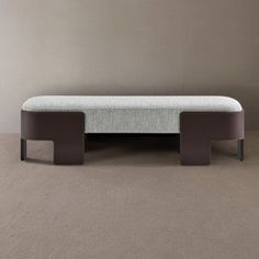 a white and brown bench sitting on top of a carpeted floor next to a wall