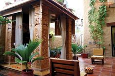 a wooden gazebo sitting on top of a patio next to a lush green plant