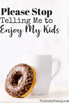 a donut sitting on top of a white coffee cup next to a wall decal