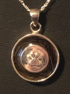 "Sterling silver circle of life dog paw pendant made with your pets hair. The center has the hair encased in it, so the color of the hair will be the color of the center stone.. Can also use your pets cremation ash for center stone. Horse shoe also available This is Sterling Silver 3/4\" round I need a 4 inch pencil round section of hair for this piece. or a teaspoon of ash PLEASE KEEP IN MIND BEFORE ORDERING: *I can combine the hair of more than one and place them in the same piece. If they are Dog Paw Pendant, Horse Hair Pottery, Paw Pendant, Horse Hair Jewelry, Pet Memorial Jewelry, Memorial Ring, Sterling Silver Heart Pendant, Ashes Jewelry, Horse Shoe