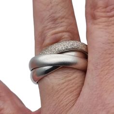 Three-band rolling ring known as a trinity ring, consists of three intertwined sterling silver rings for women, each ring with different finishes. Of contemporary manufacture. Please see all the details of this ring. Weight: 13.68 grams. Dimensions: Each ring separately has an internal diameter between 21.5 and 21.9 mm, but when you put it on your finger it makes approximately 18.2 mm that would correspond to a size 8 - 8 1/2 in the USA, it is difficult to determine since it has movement. Composition: ** Silver, stamped, also acid tested. Do not hesitate to request all the extra information you need, we will be happy to answer you. See photos for your own impression (please note photos were taken in artificial light so colors may differ) All the items we sell have their own personality, th Elegant Silver Engraved Stackable Ring, Elegant Silver Wide Band Promise Ring, Metal Rings For Formal Occasions With A Modern Twist, Formal Modern Twist Metal Rings, Silver Infinity Ring With Polished Finish, Silver Infinity Stackable Rings, Elegant Adjustable Twisted Ring, Modern Twist Silver Ring, Elegant Metal Stackable Rings For Anniversary