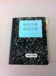 a black notebook with writing on the front cover and words written in white ink above it