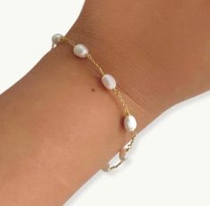 This dainty gold plated bracelet features alternating oval pearls, making it a timeless piece that will never go out of style. Whether you're looking for a subtle addition to your everyday look or a statement piece for a special occasion, the pearl chain bracelet is the perfect choice. It is dainty and elegant also perfect for wedding day or for bridesmaids gift.   PRODUCT DETAILS  Size: 6.2 inch length + 1 inch extension  Material : freshwater pearls and 18k double gold plated 925 silver chain. packaged in ILLÁRI jewelry box  free cleaning cloth included  visit our website www.shopillari.com  POLICY  30 day return policy for unworn and not damaged . shipping is paid by you for all returns. Dainty Adjustable Beaded Bracelets With Pearl Chain, Delicate Adjustable Pearl Bracelet, Dainty Adjustable Pearl Bracelet, Adjustable Dainty Pearl Drop Bracelet, Dainty Adjustable Pearl Chain Bracelet, Dainty Adjustable Pearl Drop Bracelet, Dainty Pearl Bracelets With Tiny Beads, Hypoallergenic Dainty Pearl Bracelets, Adjustable Pearl Bracelet With Delicate Chain