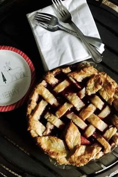 an apple pie on a plate with a fork and knife next to it, ready to be eaten