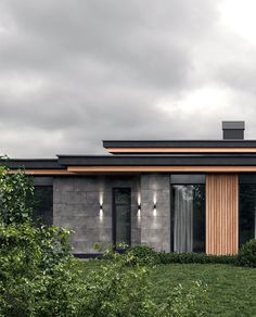 a modern house with large windows and wooden accents on the roof, surrounded by greenery