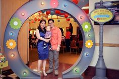 a man and woman are standing in front of a fake circle