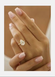 a woman's hand with pink manicured nails and a ring on her finger