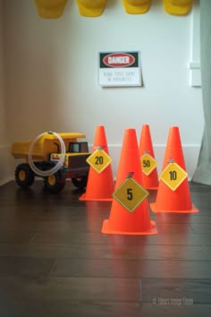 orange traffic cones sitting on top of a wooden floor