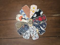 several pairs of oven mitts are arranged in a circle on a wooden table top