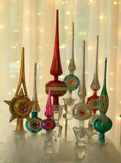 a group of colorful glass objects sitting on top of a table next to a window