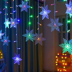 snowflakes are hanging from the ceiling in front of a window with christmas lights