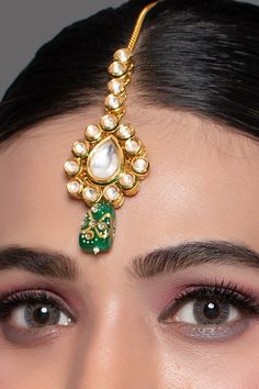 a close up of a woman wearing a head piece with pearls and beads on it