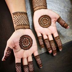 two hands with henna tattoos on them, one is showing off the intricate design