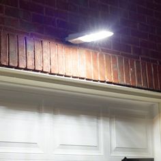 a white garage door with the light on above it