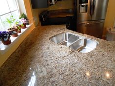 a granite counter top in a kitchen with stainless steel appliances