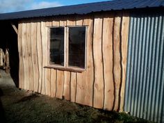 a building made out of wood and metal with a window on the side of it