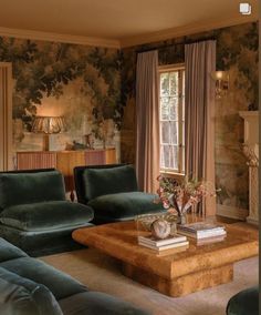 a living room filled with furniture and walls covered in floral wallpaper on the walls