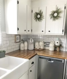 a kitchen with white cabinets and wooden counter tops, decorated for christmas or new year's eve