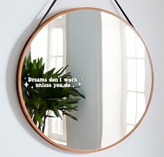 a mirror hanging on the wall that says dreams don't work unless you do