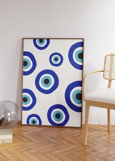 a blue and white art piece sitting on top of a hard wood floor next to a chair