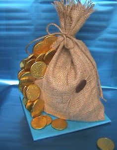 a bag filled with gold coins sitting on top of a blue table