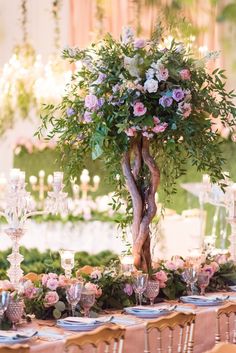 the table is set with candles, flowers and greenery for an elegant wedding reception