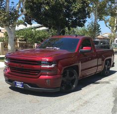 a red truck is parked on the side of the road