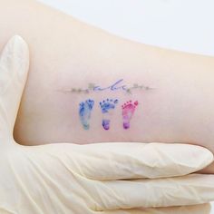 a person's arm with the word love written on it and two baby footprints